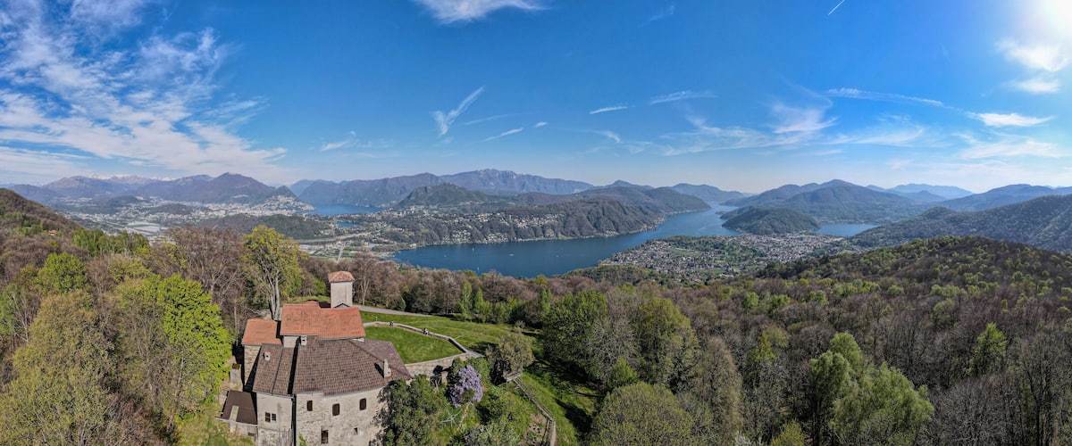 A castle overlooking a lake surrounded by mountains.