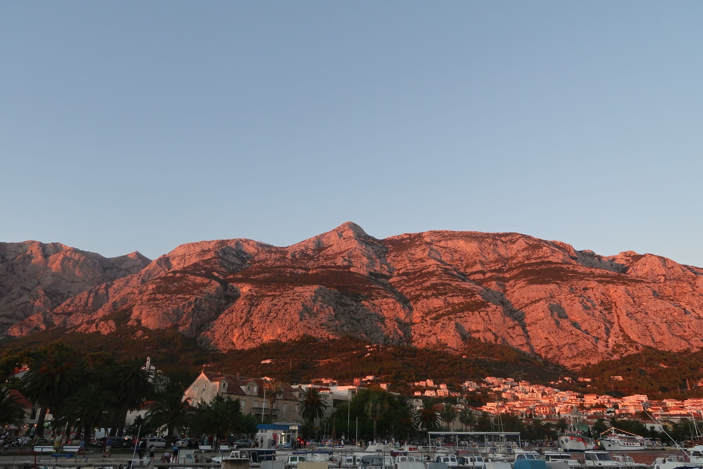 A coastal town with a mountain in the background.