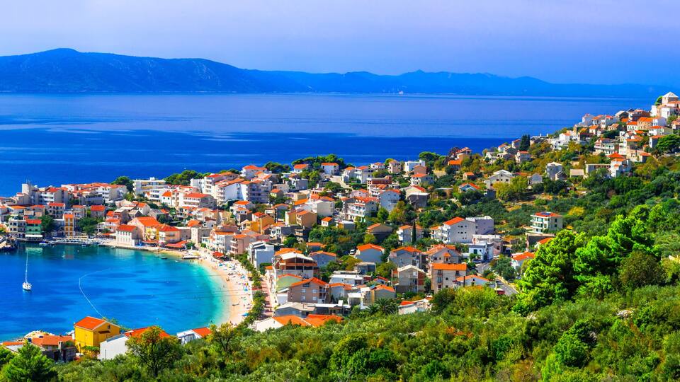 Une ville côtière avec une baie, des bâtiments et une église située sur une colline.