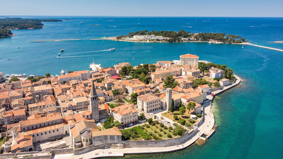 A coastal town with historic buildings, a prominent church, and a fortified wall along the waterfront.