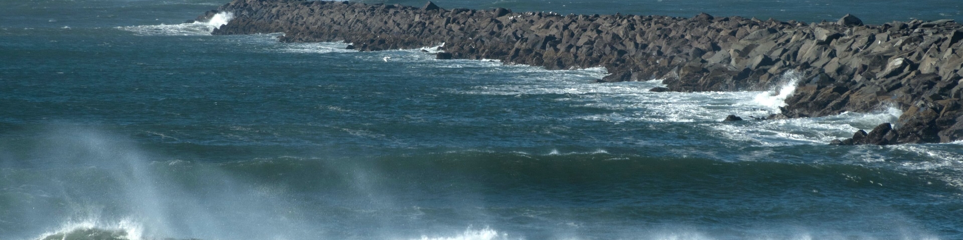 A rocky coastline with waves crashing against the rocks.