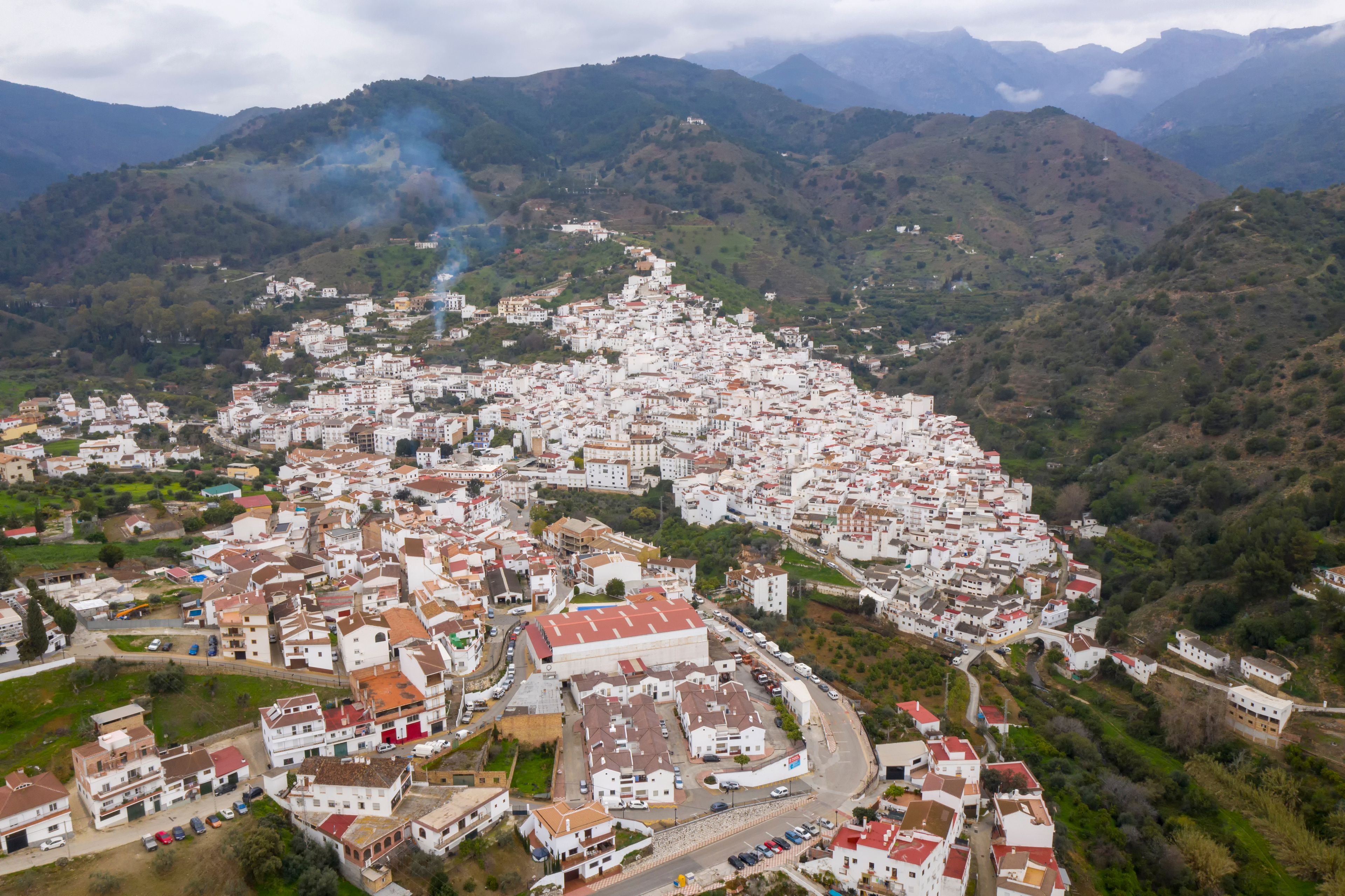 A mountainous town with white buildings and a prominent church.