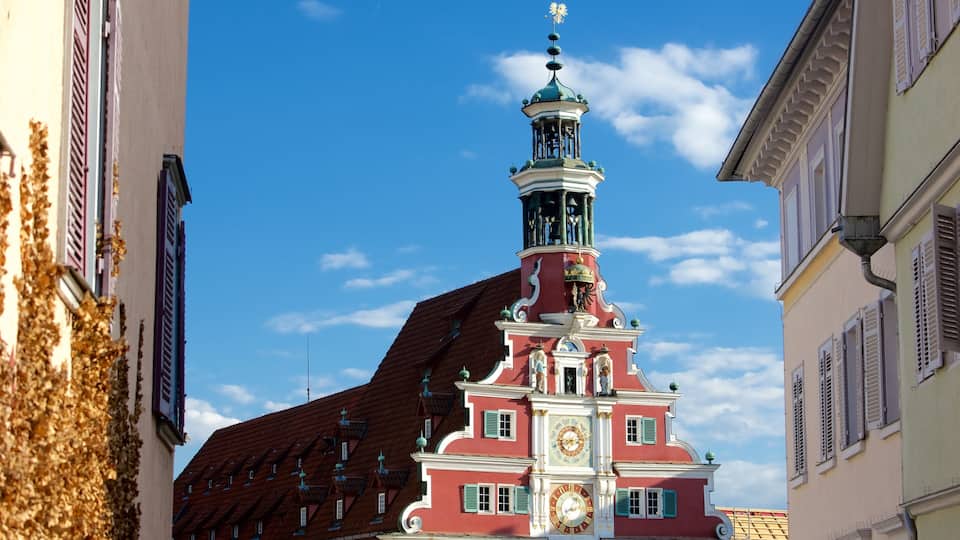 A red building with a clock tower and green windows.
