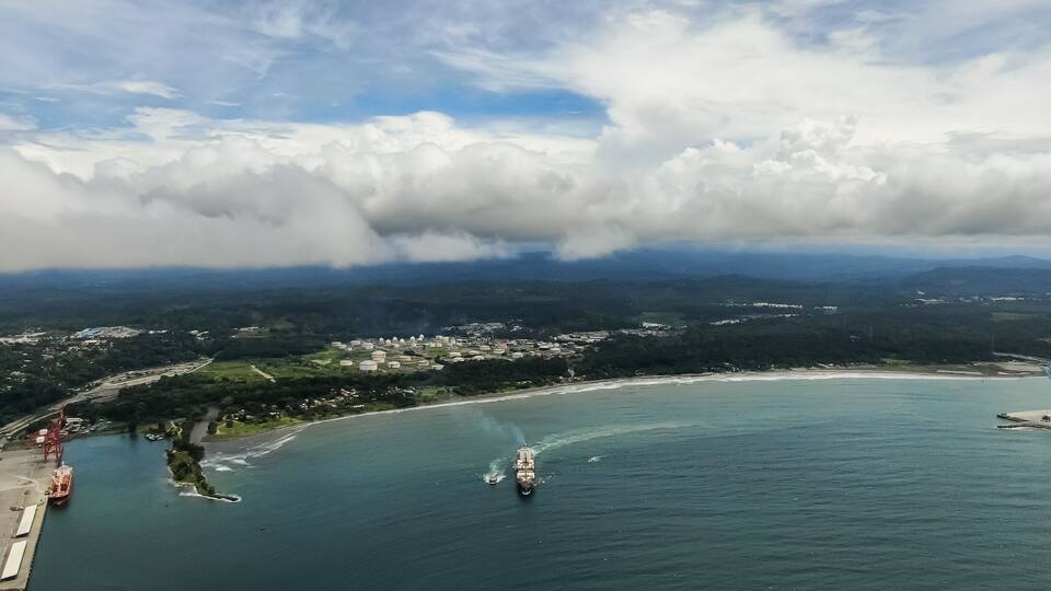 A coastal town with a harbor, boats, and a ship.