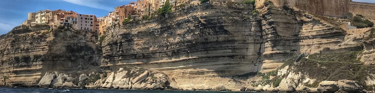 A coastal town built on a cliff with buildings perched on the edge.