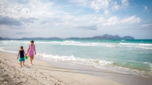 mother and son walk on a white sand beach with turquoise waters, in Playa de Muro, Palma de Mallorca, Balearic Islands, Spain, panoramic, copy space