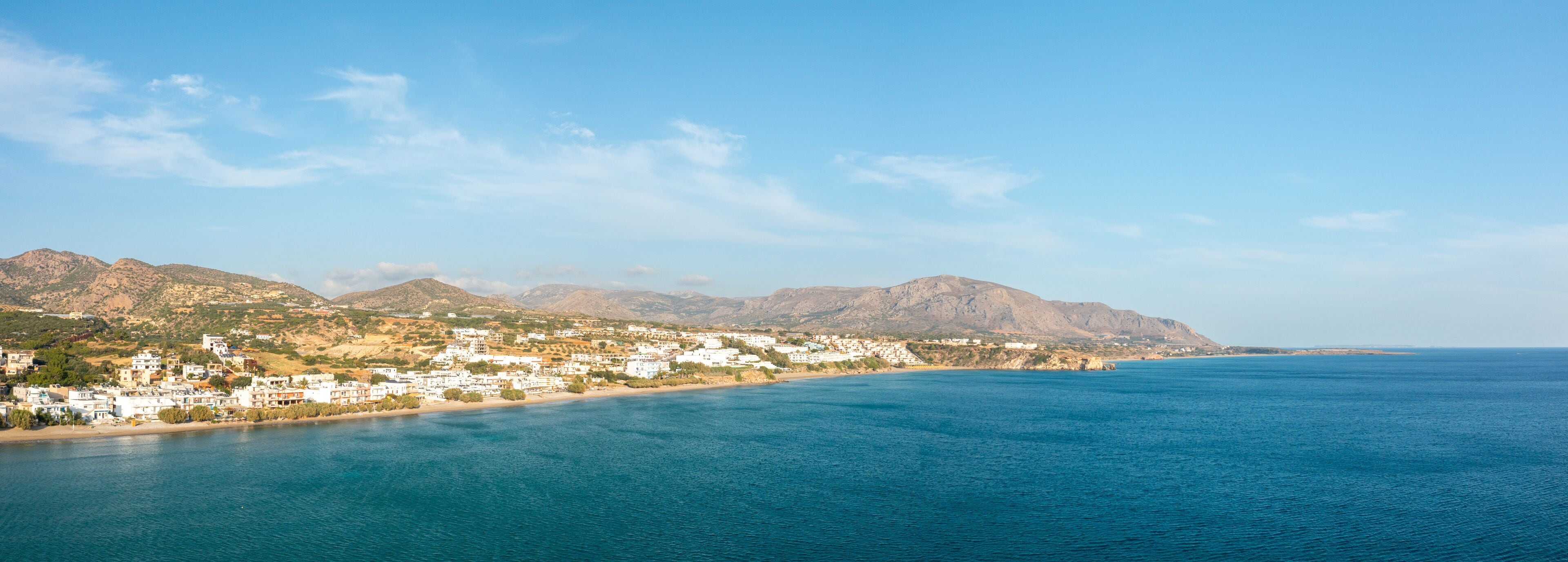 The paradise coast and the sandy beach at the foot of the mountains, in Europe, Greece, Crete, Analipsi, By the Mediterranean Sea, in summer, on a sunny day.