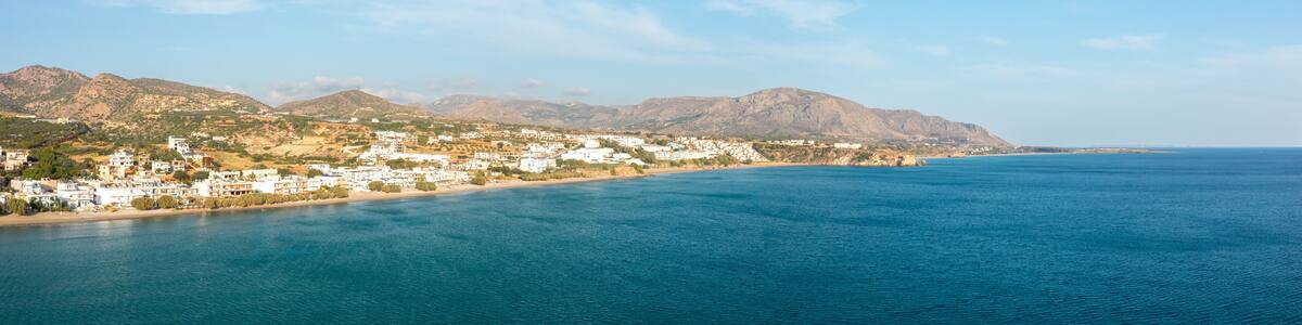 The paradise coast and the sandy beach at the foot of the mountains, in Europe, Greece, Crete, Analipsi, By the Mediterranean Sea, in summer, on a sunny day.