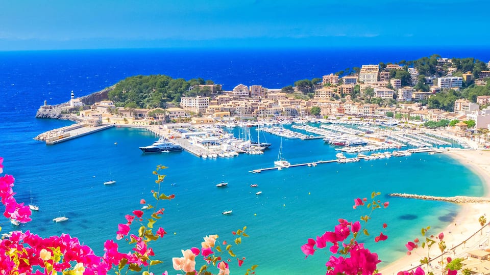 A coastal town with a marina, boats, and a beach.
