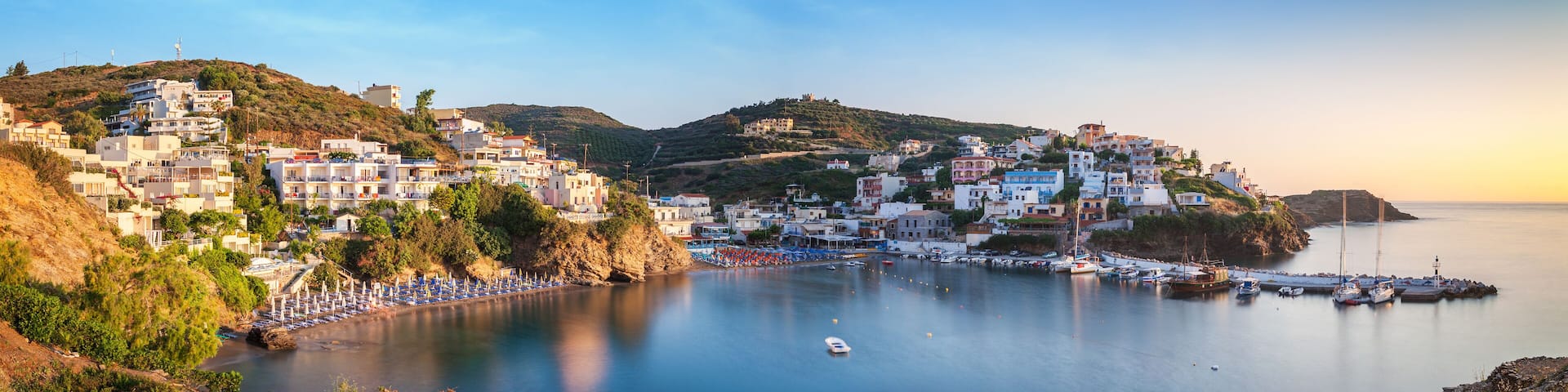 Panorama of Harbour with vessels, boats, beach and lighthouse in Bali at sunrise, Crete, Greece