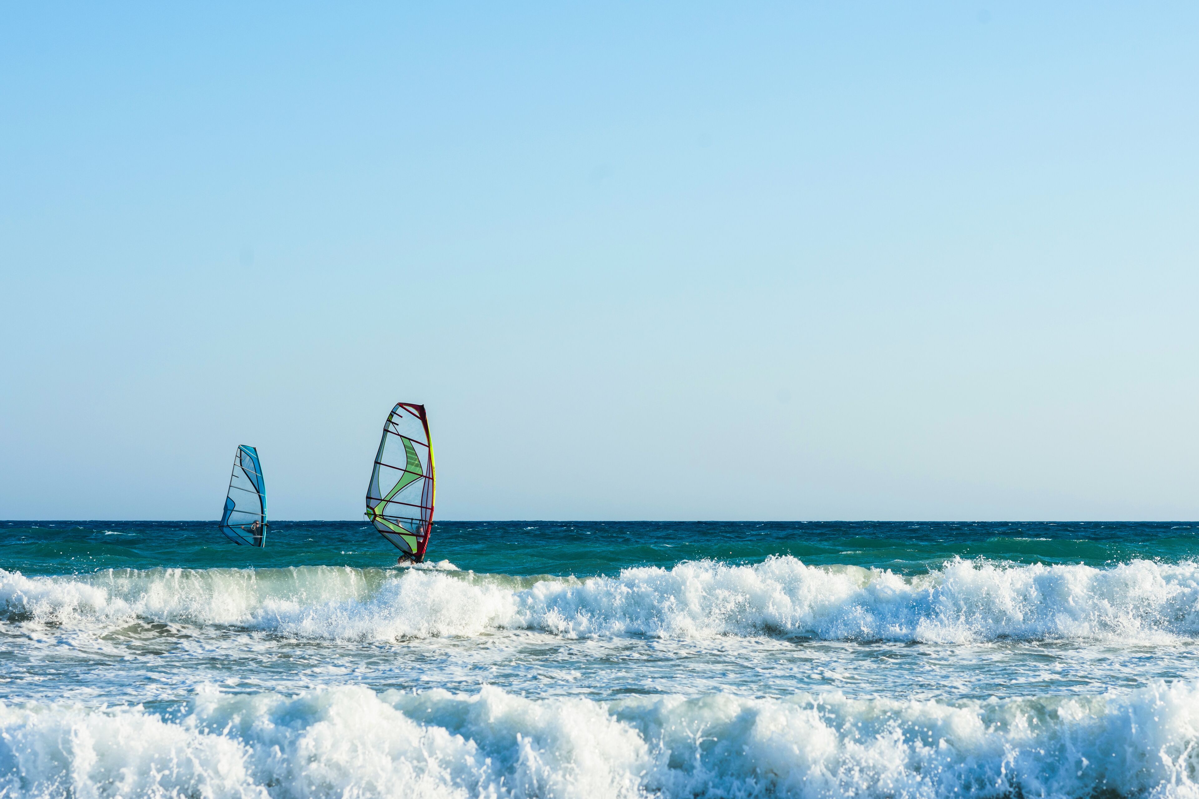 Windsurfers in the sea on Crete on sunset. Windsurfing in Heraklion