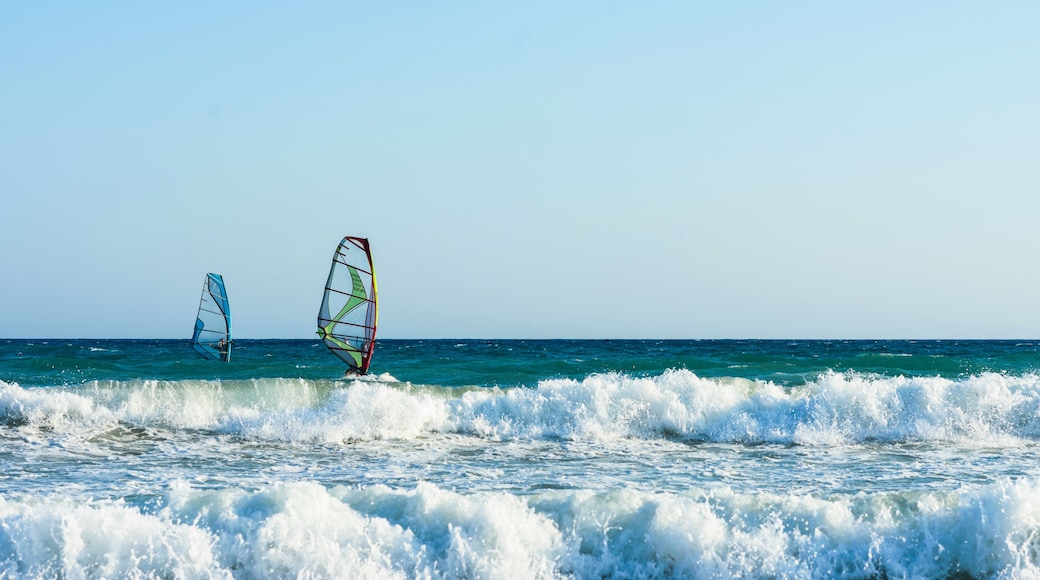 Windsurfers in the sea on Crete on sunset. Windsurfing in Heraklion