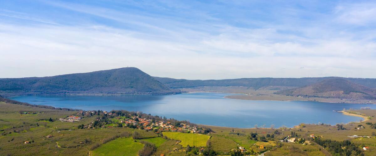 A lake surrounded by hills and a small village.
