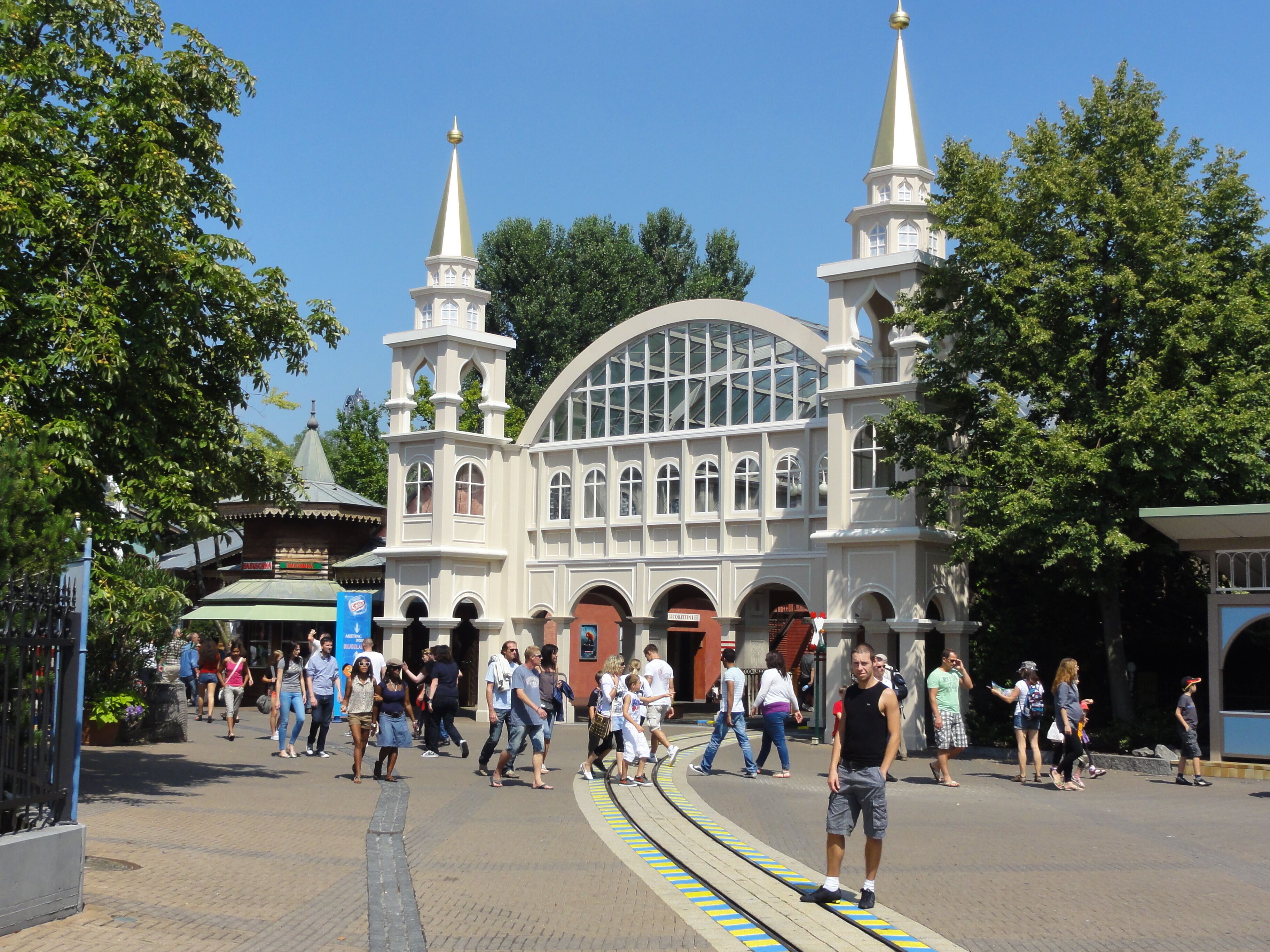 A large white building with two spires and a curved glass facade.