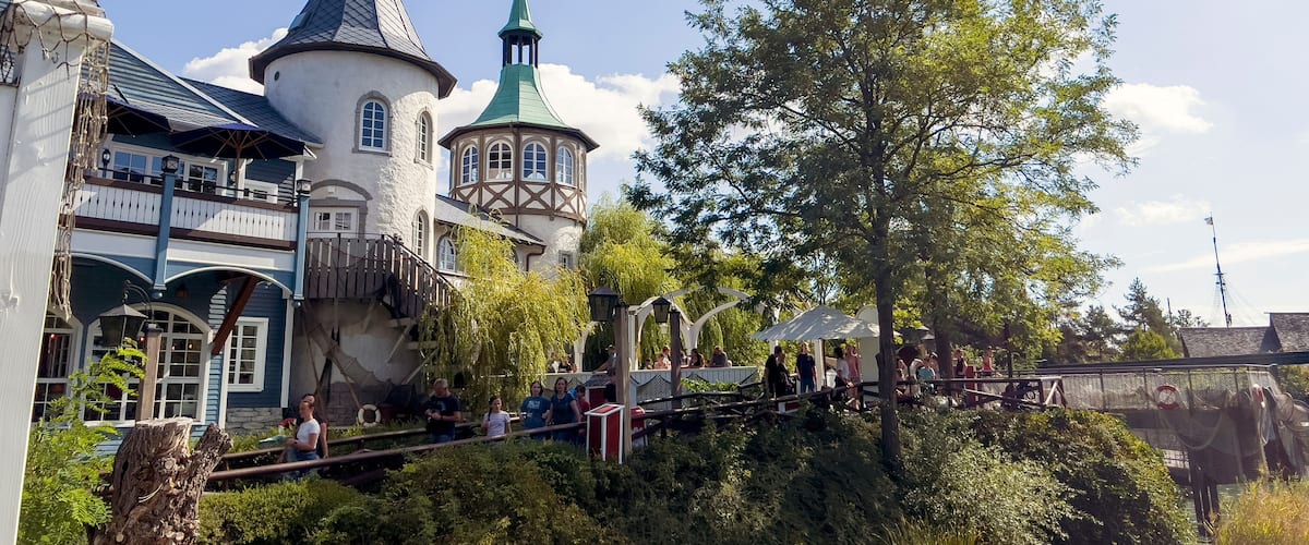 A castle-like building with multiple towers and a bridge over a river.