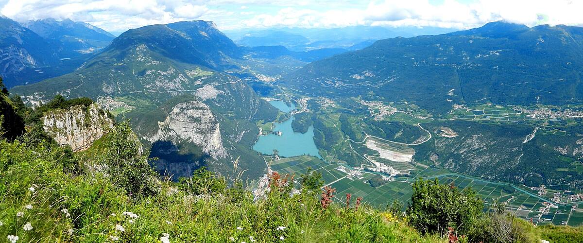 A mountainous landscape with a valley, a lake, and agricultural fields.