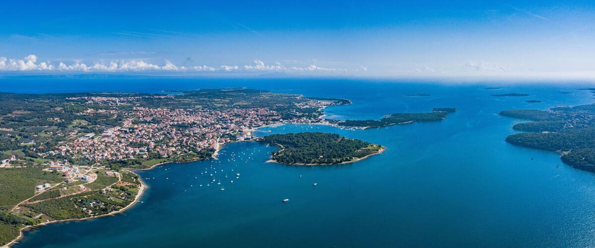 Aerial shot of the ocean in Medulin, Croatia with small green island