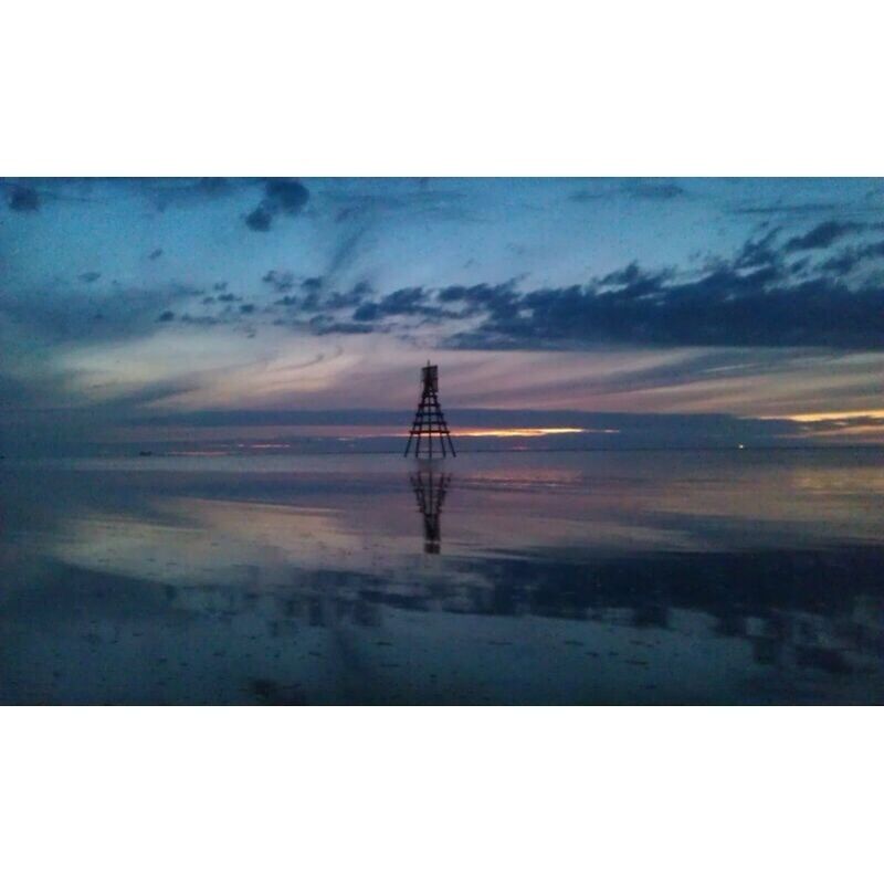 A transmission tower silhouetted against a twilight sky.