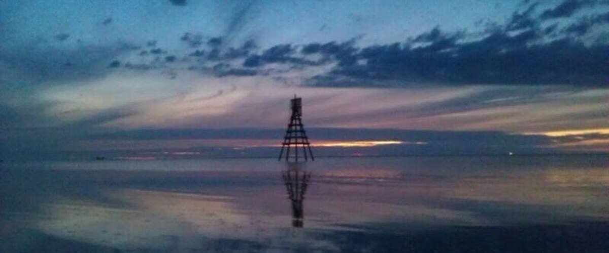 A transmission tower silhouetted against a twilight sky.