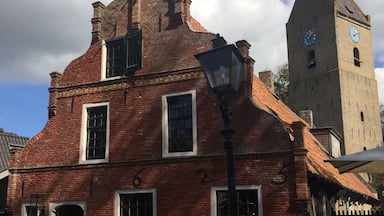 Characteristic Commandeur house on Ameland (Nes). In the background the village tower of Nes, Valerius (Watse) Frans van Cammingha and Rixt van Donia, lord and lady of Ameland instructed to build this tower in 1664. It served as a beacon for ships at sea.
