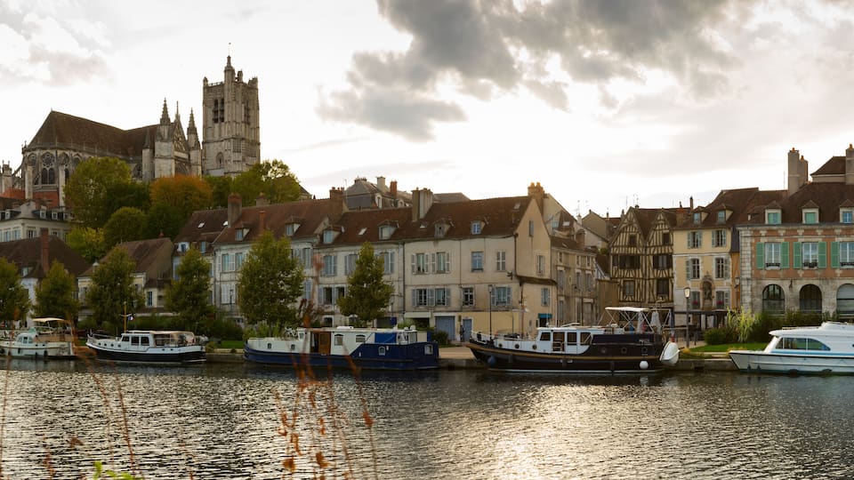 A river with boats, historic buildings, and a church.