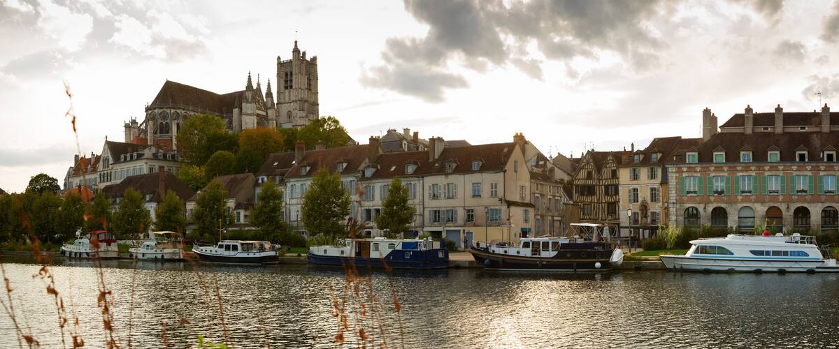 A river with boats, historic buildings, and a church.
