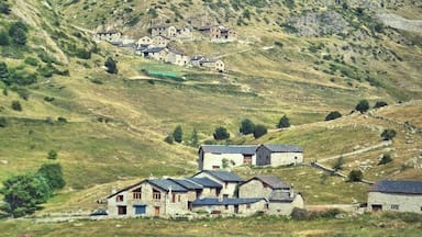 Un pueblo rural enclavado en un valle, con una colina destacada al fondo.