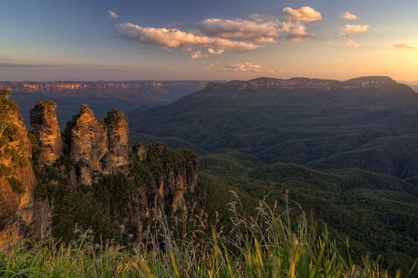 A mountainous landscape with prominent rock formations and dense forest.