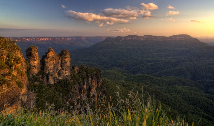 A mountainous landscape with prominent rock formations and dense forest.