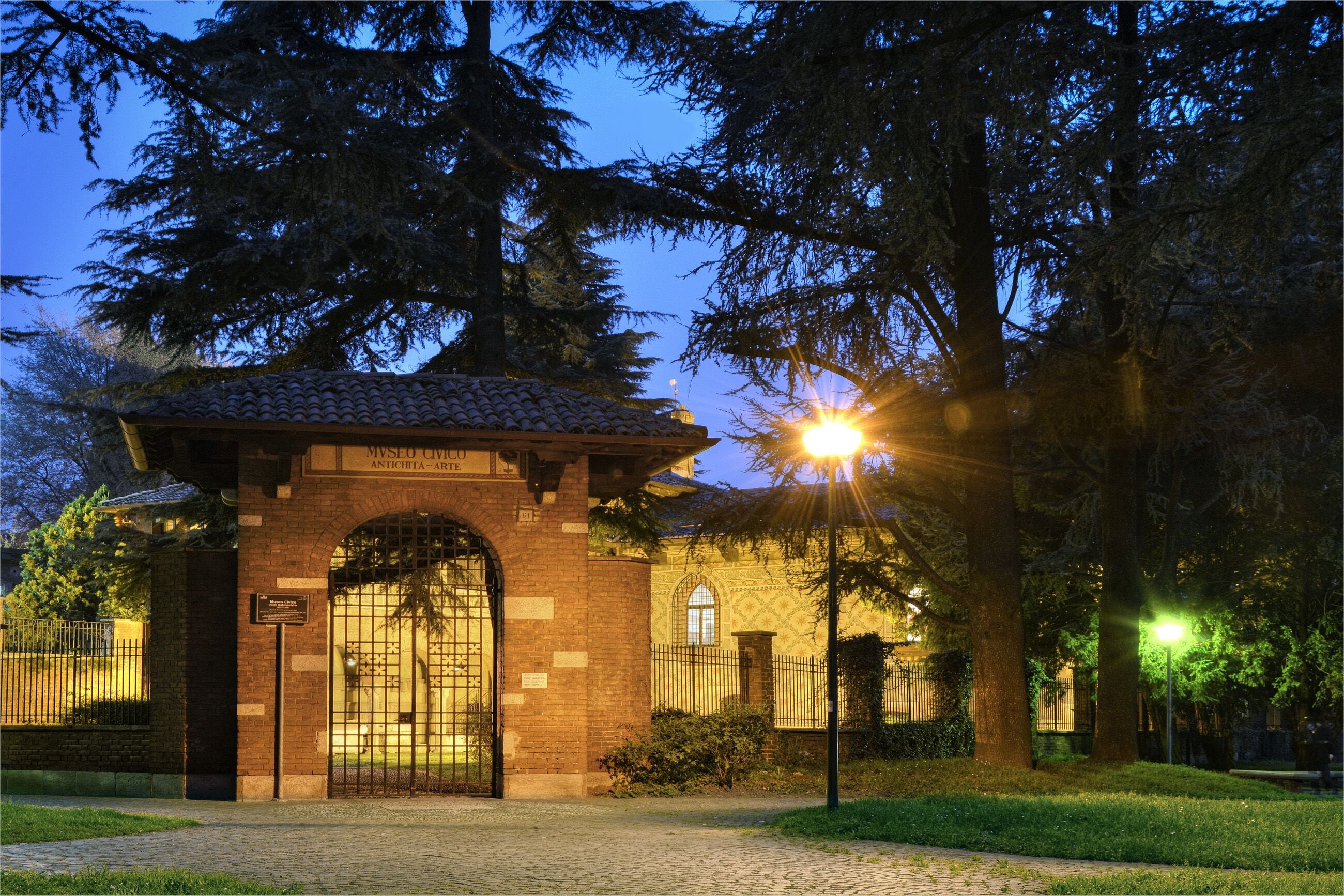 A museum entrance with a tiled roof, brick walls, and an arched gate.
