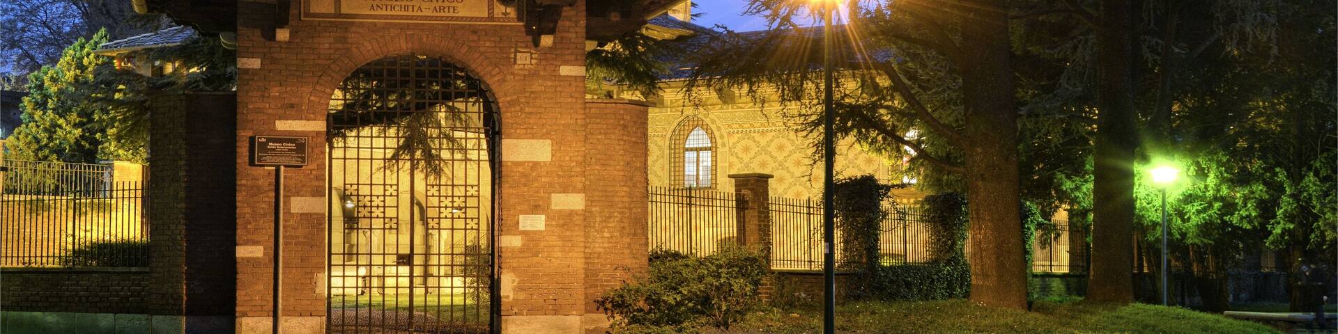 A museum entrance with a tiled roof, brick walls, and an arched gate.