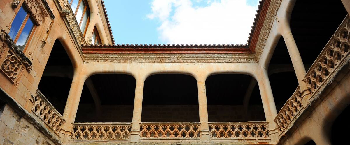 A courtyard with arches and a tiled roof.