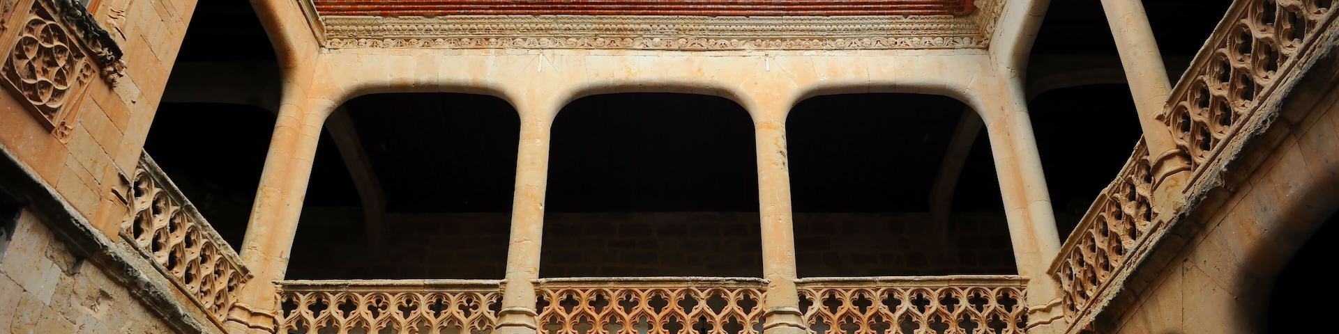 A courtyard with arches and a tiled roof.