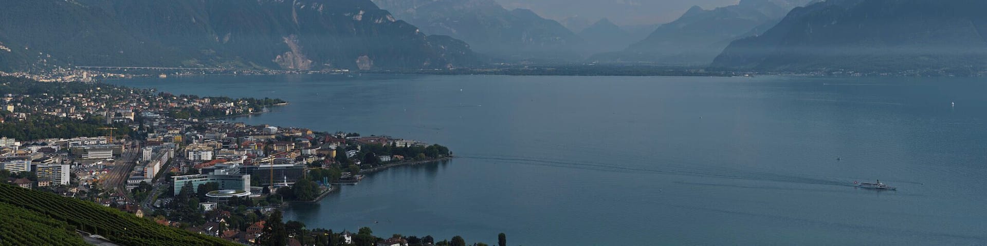 A panoramic view of a coastal city with mountains in the background.