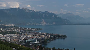 Vista panorâmica de uma cidade costeira, com montanhas ao fundo.