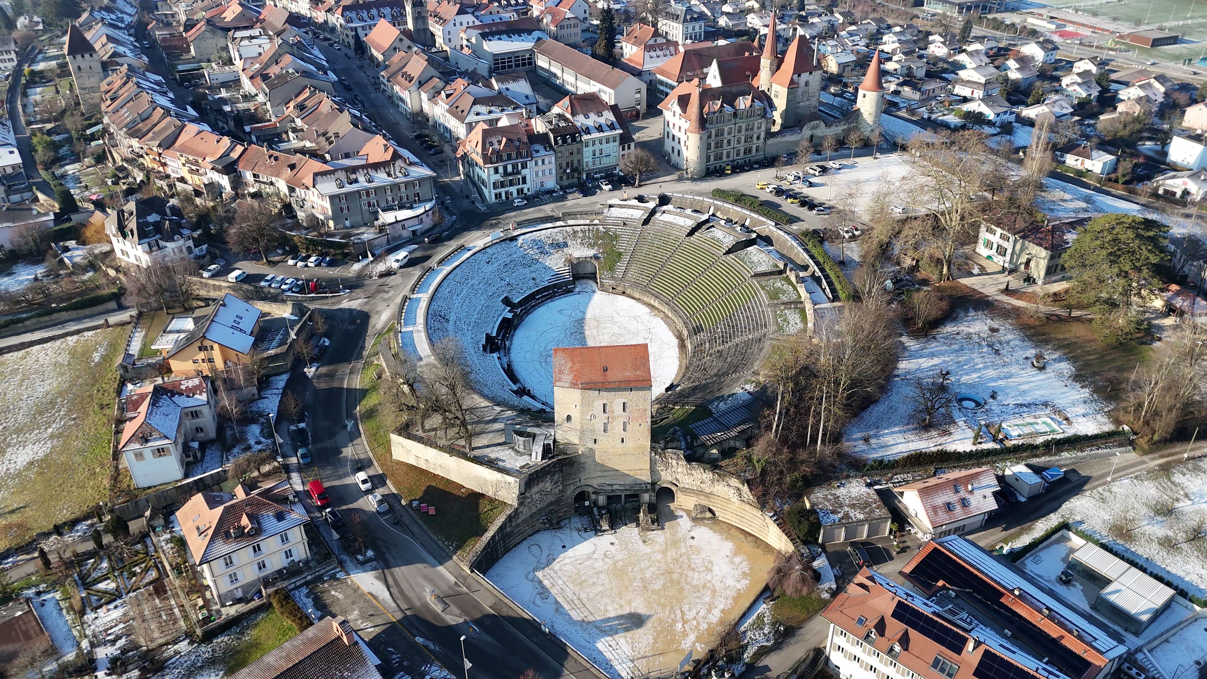Aerial winter view of ancient Roman amphitheater surrounded by historic town in Switzerland