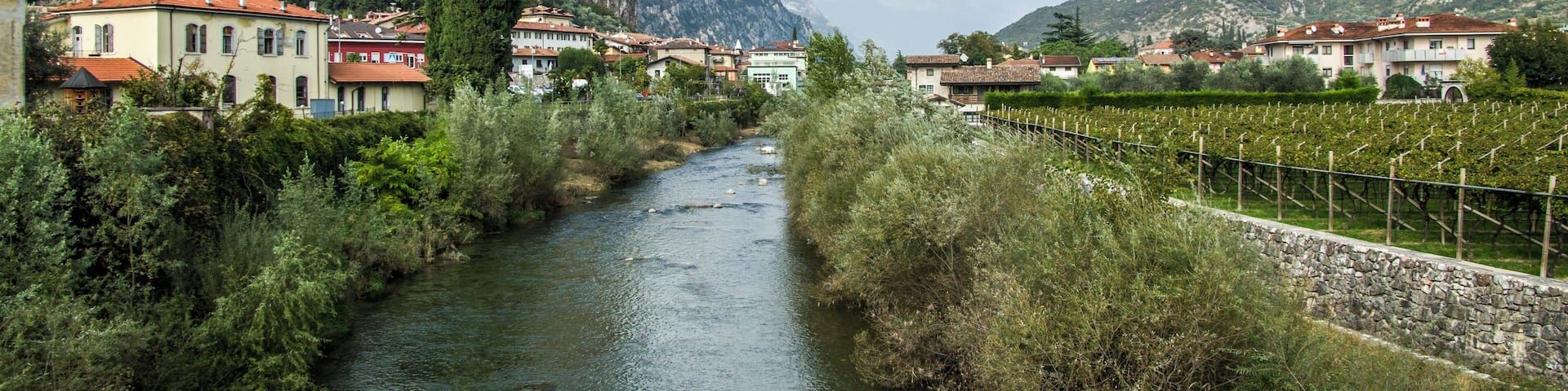 A river flowing through a town with buildings and a castle on a hill.