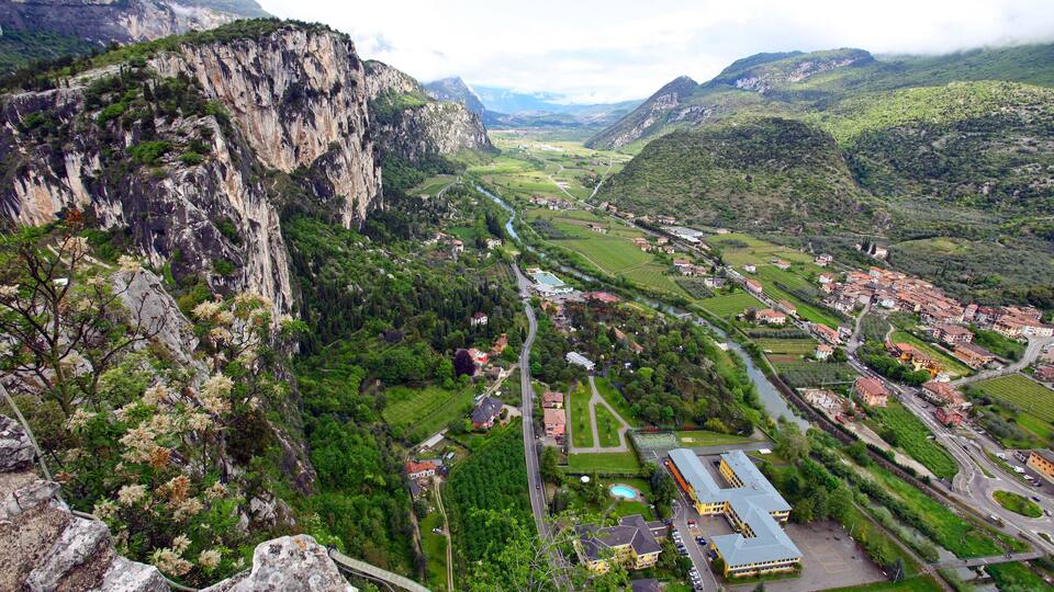 A mountainous landscape with a river, a small town, and a school building.