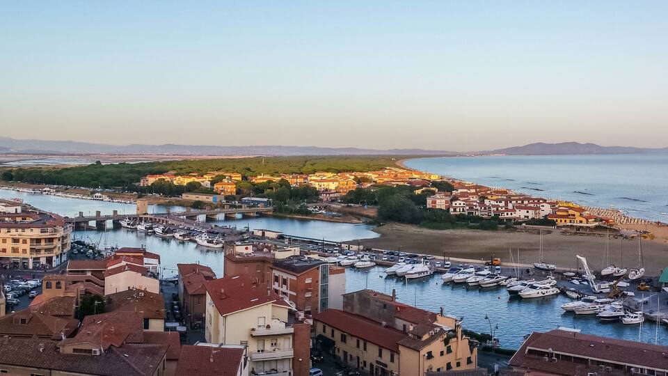 A coastal town with a marina, buildings, and a river.