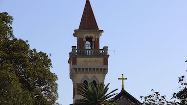 A church tower with a red roof and a cross at the top.