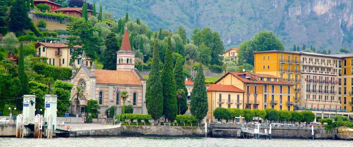 A lakeside town with a church, a bridge, and colorful buildings.