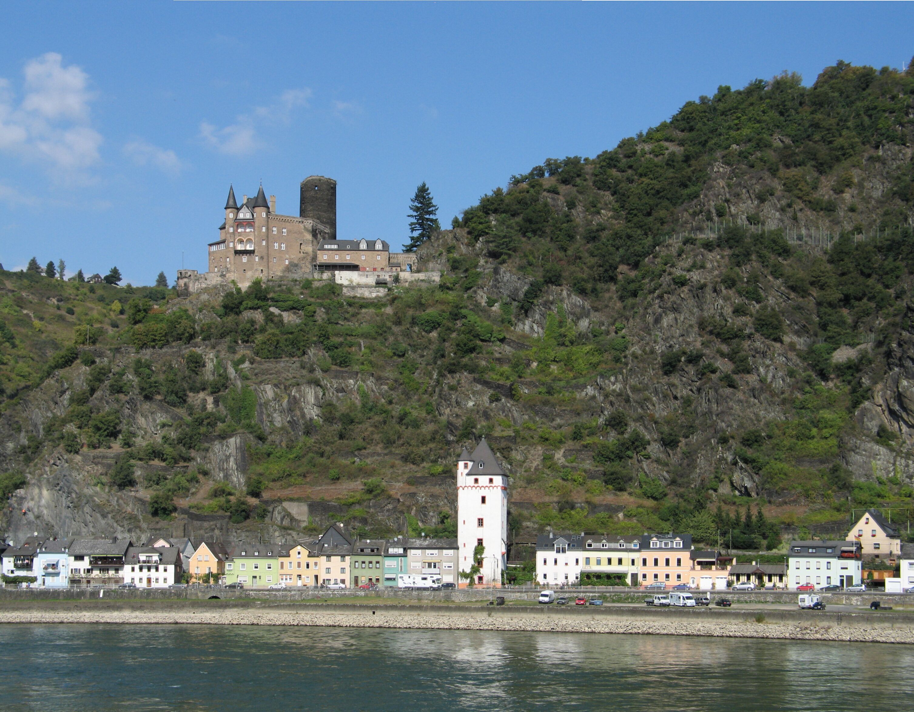 A castle on a hill with a river in the foreground.