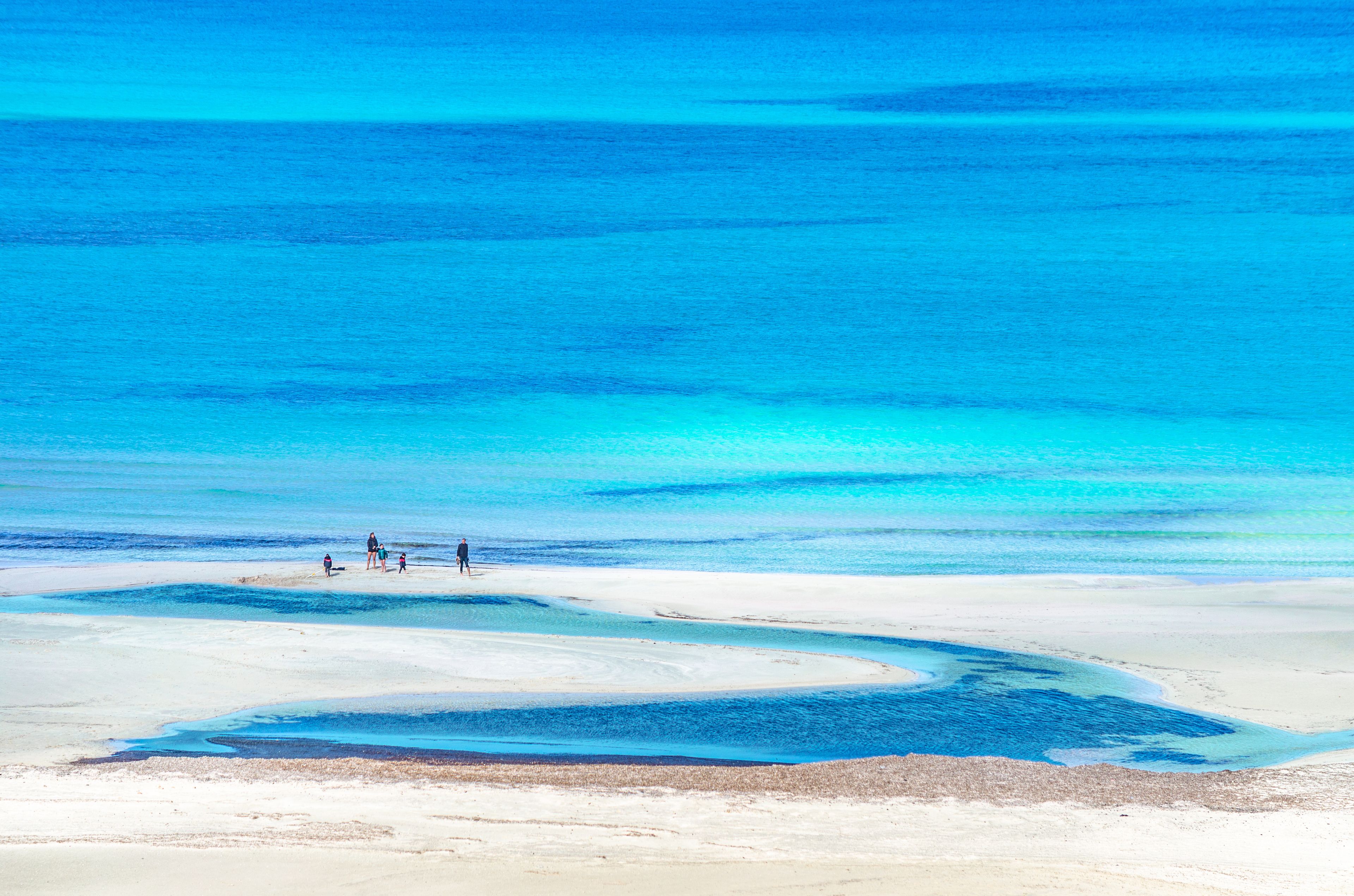 View of the amazing beach of Balos, with a family playing on the tropical sandy beach with turquoise waters, Crete, Greece