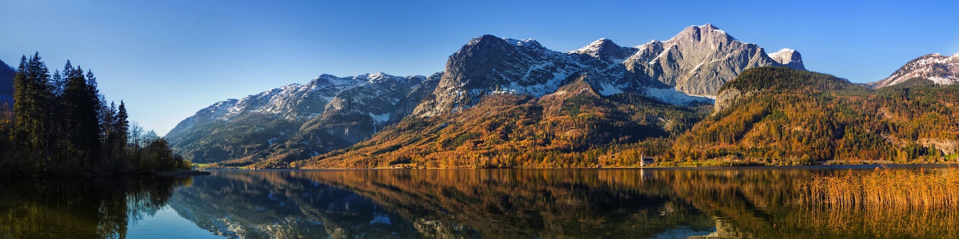 A mountain range with a clear lake reflecting the scenery.