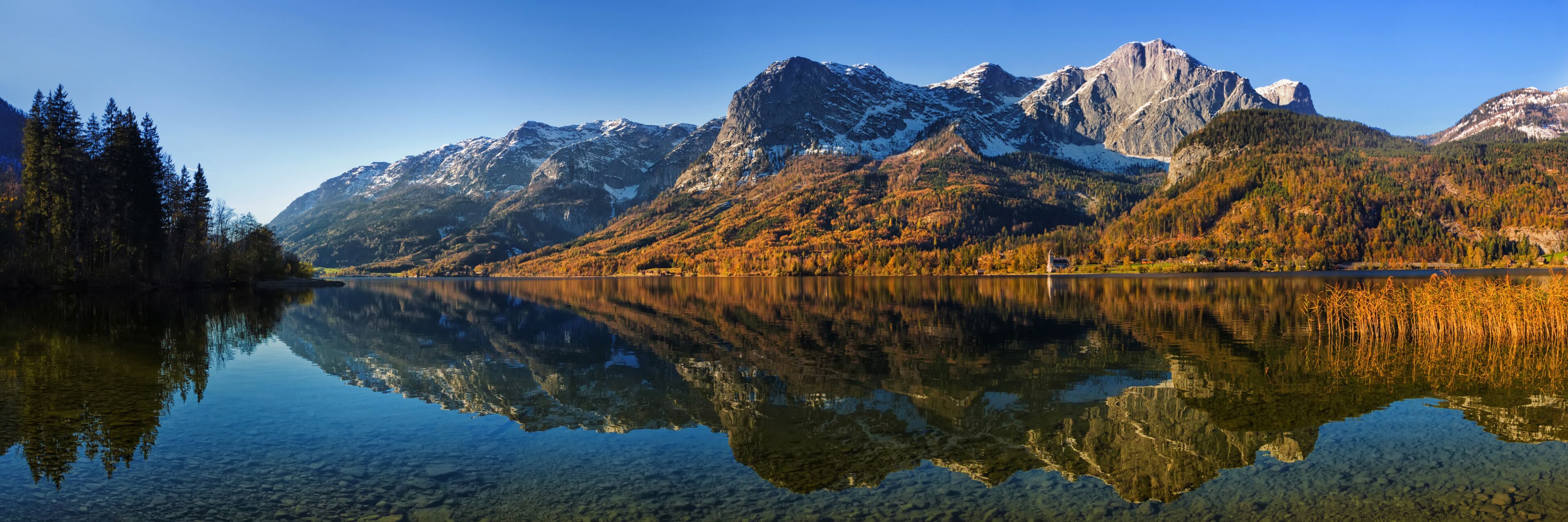 A mountain range with a clear lake reflecting the scenery.