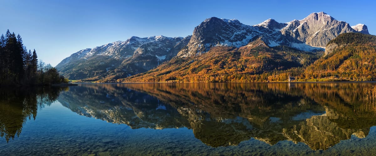 A mountain range with a clear lake reflecting the scenery.