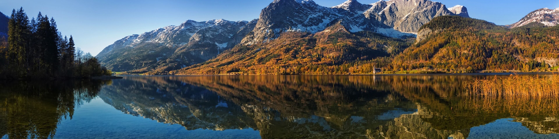 A mountain range with a clear lake reflecting the scenery.