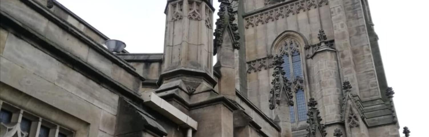 A Gothic-style church with a tall clock tower and intricate stonework.