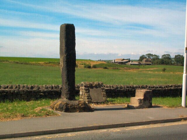Long Stoop. At the western side of the main Airport roundabout of the A658. The accompanying stone inscription reads: 'THIS MARKER STONE (LONG STOOP) ERECTED HUNDREDS OF YEARS AGO TO GUIDE TRAVELLERS TOWARDS AN ANCIENT SETTLEMENT AT DENE HEAD TO THE EAST WAS MOVED FROM ITS EARLIER SITE 186 YARDS TO THE SOUTH WEST IN THE YEAR 1984 FOR RUNWAY EXTENSIONS. AIREBOROUGH CIVIC SOCIETY.'