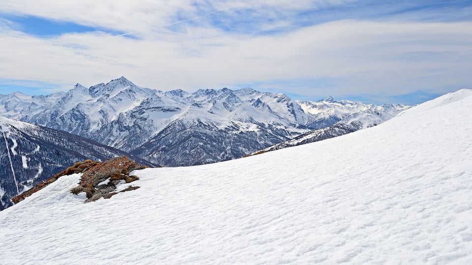 A snow-covered mountain range with rugged peaks and a clear sky.